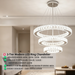 3-tier white circular LED ring chandelier suspended above a modern bed, emitting warm white light – Mega Lighting