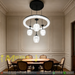 Black dual-layer crystal LED chandelier with 4 textured glass shades, installed in a minimalist European dining room with warm 3000K lighting.