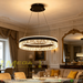 Black modern crystal ring LED pendant light, 50cm diameter, installed in a minimalist European dining room with warm 3000K lighting.