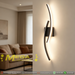 Modern 60cm black curved LED wall light installed on a staircase wall, emitting warm white light – Mega Lighting