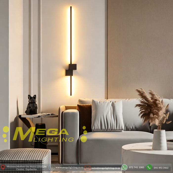 60cm matte black linear LED wall light installed on a living room wall, emitting warm white light – Mega Lighting