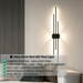 Modern staggered vertical LED wall sconce with three rods, mounted beside a sofa – Mega Lighting