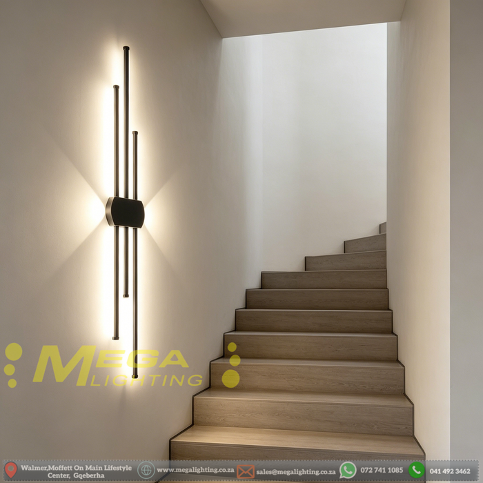 Modern staggered vertical LED wall sconce with three rods, mounted beside a sofa – Mega Lighting