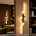 60cm matte black zig-zag wave LED wall light installed in a modern living room, emitting warm white light – Mega Lighting
