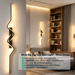 60cm matte black zig-zag wave LED wall light installed in a modern living room, emitting warm white light – Mega Lighting