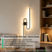 61cm matte black U-shaped looped LED wall light installed in a modern living room, emitting warm white light – Mega Lighting