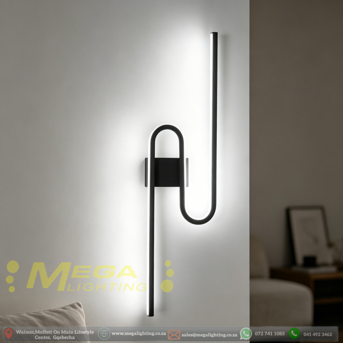 61cm matte black U-shaped looped LED wall light installed in a modern living room, emitting warm white light – Mega Lighting