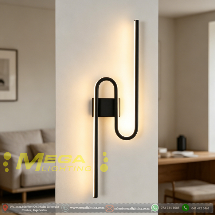 61cm matte black U-shaped looped LED wall light installed in a modern living room, emitting warm white light – Mega Lighting
