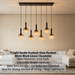 7-light smoke gradient glass pendant light with matte black frame, linear design, warm glow above a dining table