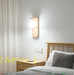 Artistic faux wood spherical glass wall light with curved wood panel and milky glass globe, warm 3000K glow for bedroom bedside.