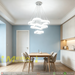 3-tier white cloud-shaped LED chandelier installed above a modern dining table, emitting warm white light – Mega Lighting