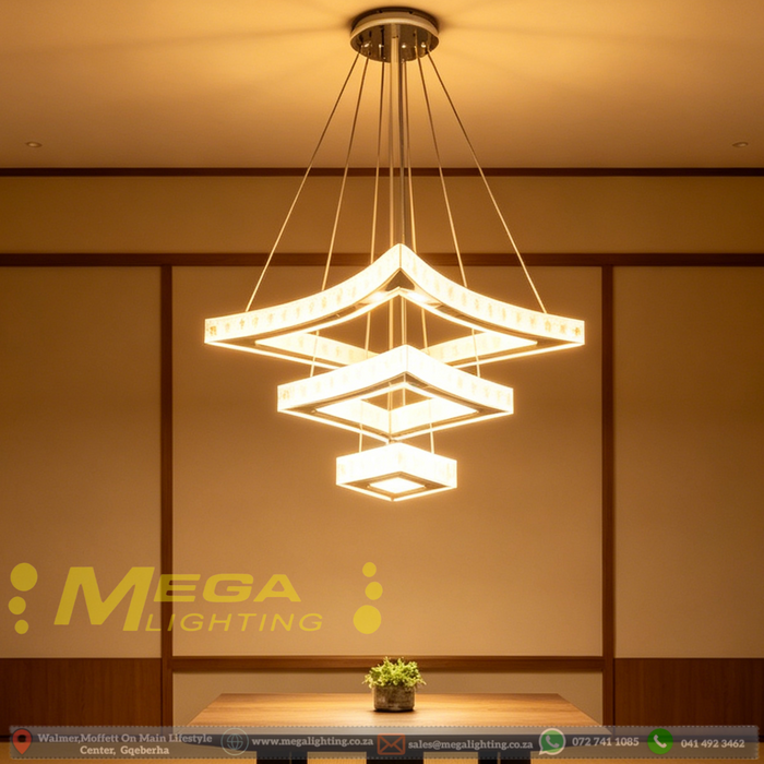 Modern 3-tier square white LED chandelier suspended above a dining table with warm white lighting – Mega Lighting
