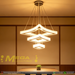 Modern 3-tier square white LED chandelier suspended above a dining table with warm white lighting – Mega Lighting