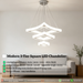 Modern 3-tier square white LED chandelier suspended above a dining table with warm white lighting – Mega Lighting