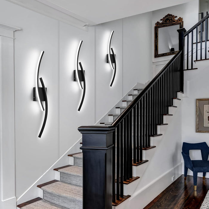 Modern 60cm black curved LED wall light installed on a staircase wall, emitting warm white light – Mega Lighting