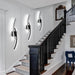 Modern 60cm black curved LED wall light installed on a staircase wall, emitting warm white light – Mega Lighting