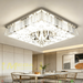 Modern LED crystal ceiling light with faceted crystal pendants and mirrored finish, installed in a contemporary living room, warm 3000K glow.