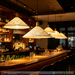 White perforated cone pendant light with brass accents, E27 bulb base, 100cm height, 35cm diameter, over modern bar and dining counter.
