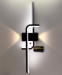 Sleek black curved LED wall light in cool white light, displayed in a minimalist living room – Mega Lighting